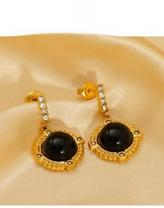 Vue macro de boucles d'oreilles rétro en acier titane avec pierre noire et cristaux brillants