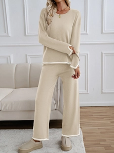 Detail of beige knitted lounge set with contrast white trim on cuffs and hemline
