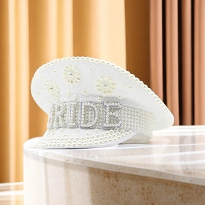Detail of white bride captain hat featuring elegant pearl embellishments and BRIDE lettering