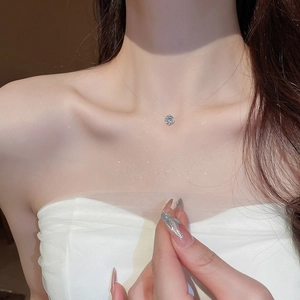 Dettaglio di un ciondolo in zircone rotondo su una collana a filo di pesca invisibile