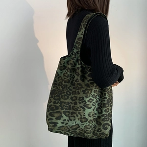 Ampia borsa tote in tela con stampa leopardata verde indossata dalla modella