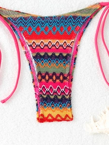 Close-up of vibrant crochet bikini bottoms with colorful geometric patterns and side ties