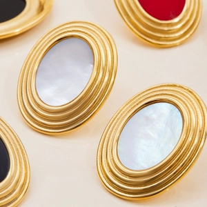 Macro shot of 18K gold plated stainless steel oval earrings with white mother of pearl inlay