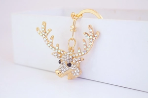Close-up of golden reindeer keychain with sparkling crystals and detailed rhinestones