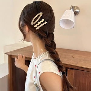 Acetate hair clip set with marble patterns shown on elegant braided hairstyle