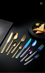 Detailed close-up of golden and rainbow stainless steel cutlery with ribbed handles