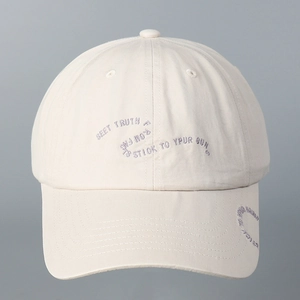 Close-up of English embroidery on beige cotton baseball cap with ventilation eyelets