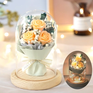 Preserved orange roses in glass dome with wood base and warm lighting for Valentines gift