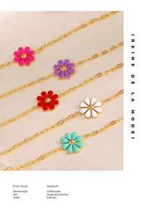 Close-up of golden link bracelets with colorful enamel daisy charms in five sweet colors