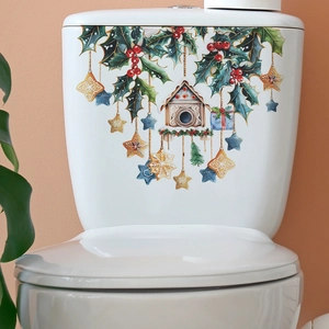Close-up of Christmas holly and birdhouse stickers applied to a white toilet tank