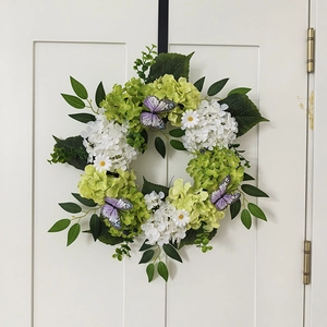 Detail of autumn hydrangea wreath with purple butterflies on a white door