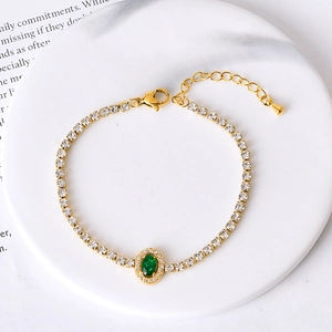 Elegant gold titanium steel bracelet with white zircons and an emerald green oval stone