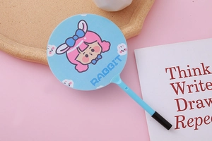 Close-up of sky blue cartoon angel pen on a desk with a notebook and aesthetic tray