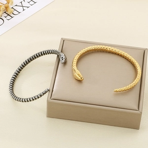 Chic snake-shaped open bracelet in silver and gold with intricate scale textures