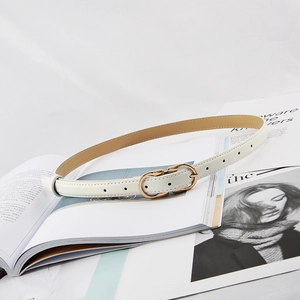 Detail view of a white leather thin belt with a gold metal horse-bit buckle on a magazine