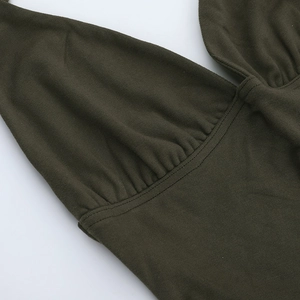Détail de la robe en maille vert olive montrant le décolleté en V et le métal