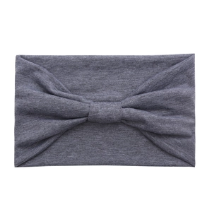 Detail view of a soft grey cotton wide yoga headband with a stylish knot design