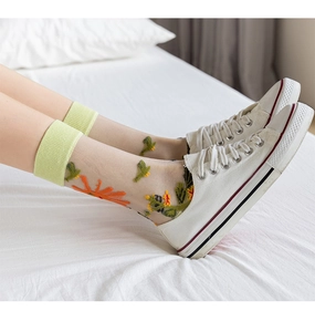 Detailed close-up of semi-transparent mesh crew socks with orange floral and bird embroidery