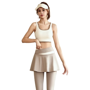 Three-piece women's yoga set with white sports bra, beige pleated skirt, and sun hat