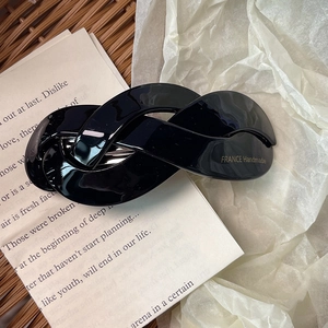 Detail of a handmade black twisted acetate hair clip showing the France Handmade gold stamp