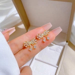 Elegant gold bow earrings with micro-inlaid zircons and sparkling dangling diamond drops