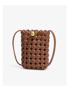 Detail of brown woven bucket bag featuring a decorative gold ball clasp and slim strap