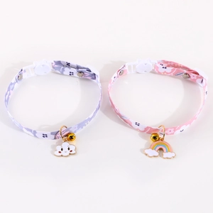 Close-up of adjustable pet collars with floral patterns, bells, and rainbow pendants