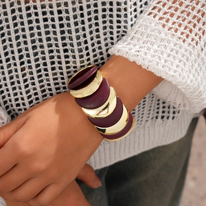 Dettaglio del bracciale in resina acrilica con dischi circolari color oro e bordeaux