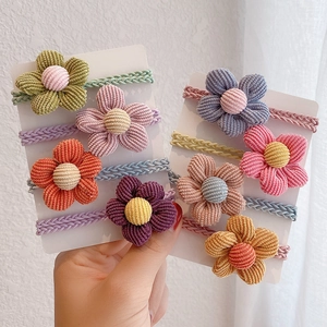 Vista dettagliata di 10 elastici per capelli con fiori di velluto a coste su carta