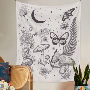 Detail of bohemian tapestry featuring butterfly and moon phases in a cozy room setting