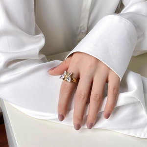 Bague papillon élégante en or avec zircons portée par un mannequin en chemise blanche