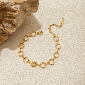 Detail of 18K gold stainless steel bracelet with sun pendant and zircon stone inlay