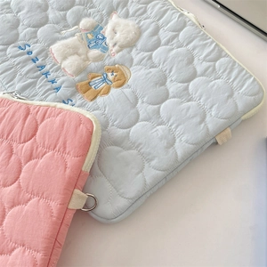 Close-up of quilted cloud pattern with cute bear embroidery on tablet storage bags