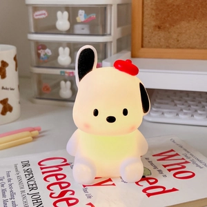 Close-up of a cute dog night light with a red beret glowing on a bedside table