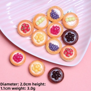Close-up of miniature 2cm resin fruit tart charms with detailed strawberry and grape toppings