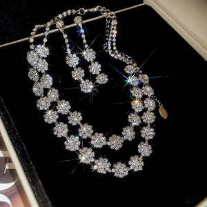 Detailed view of diamond-studded double flower necklace and earrings in a luxury gift box