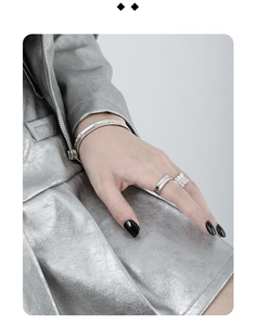 Close-up of S925 sterling silver matte bangle and butterfly rings on model's hand