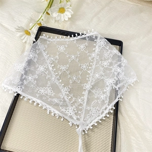 Close-up of white lace triangle bandana with floral embroidery and scalloped edges