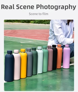 Macro shot of colorful matte stainless steel water bottles displayed at a sports field