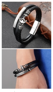 Detail of men's braided leather bracelet with silver anchor clasp and magnetic closure