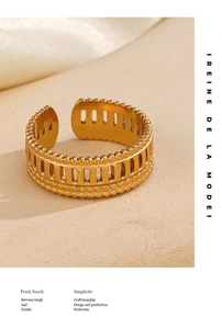 Detail of adjustable gold roman ring with geometric cutouts on beige stone and silk
