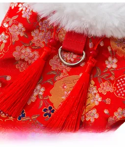 Close-up of red Chinese pet vest with bamboo embroidery, metal D-ring and red tassels