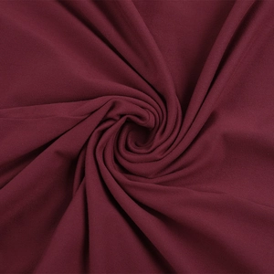 Nahaufnahme von weinrotem Strickstoff mit eleganten, spiralförmigen Drapierungen