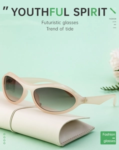 Nahaufnahme einer ovalen beigen Sonnenbrille auf einem Lederetui vor minzgrünem Grund