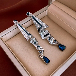 Detail of silver drop earrings with blue zircon inlays and crystal geometric spirals