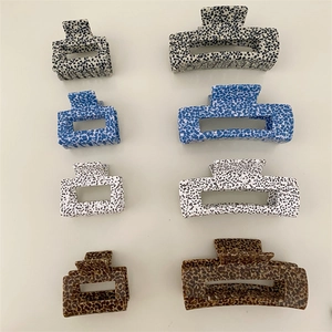 Detail view of square hair claws in spotted, floral, and tortoiseshell patterns