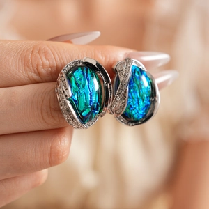 Detail shot of vintage silver earrings with teal resin gemstone and sparkling rhinestones