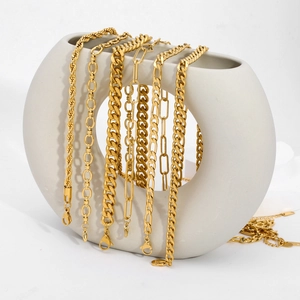 Detail of layered 18K gold plated stainless steel blade necklaces on a white ceramic vase