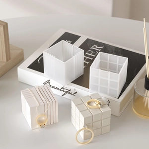 Minimalist white textured cube display stand with elegant gold jewelry for product photos