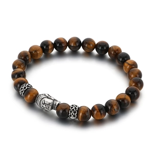 Beaded tiger eye stone bracelet with metal buddha head and engraved spacers on white base
